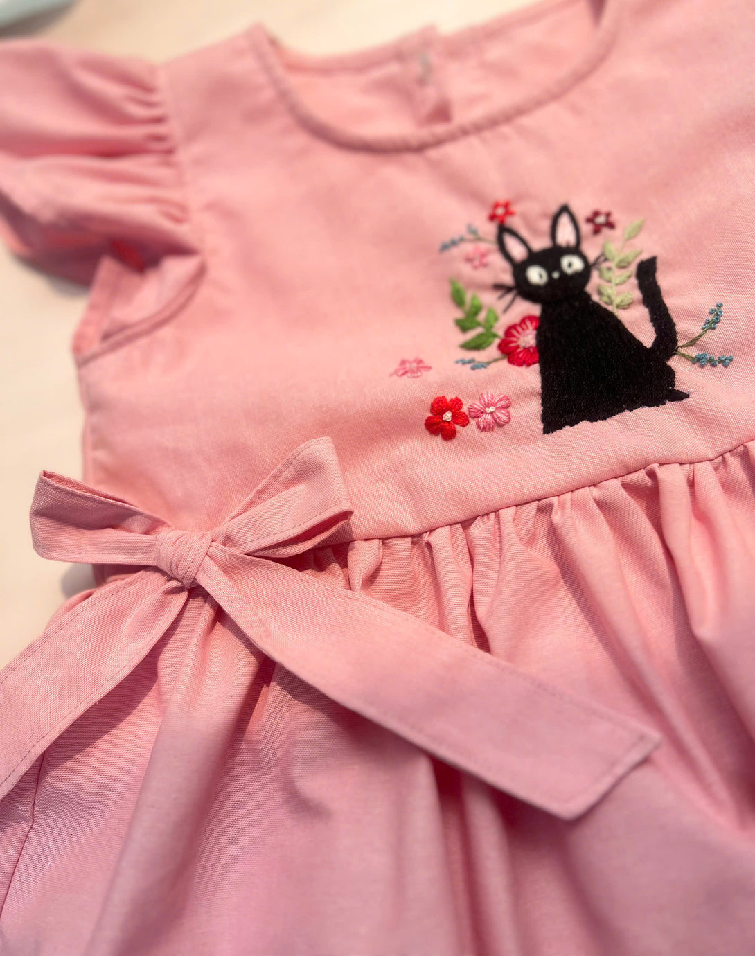 Black Cat Hand Embroidered Pink Dress with puff sleeves and bow detail by Stitchery Zone
