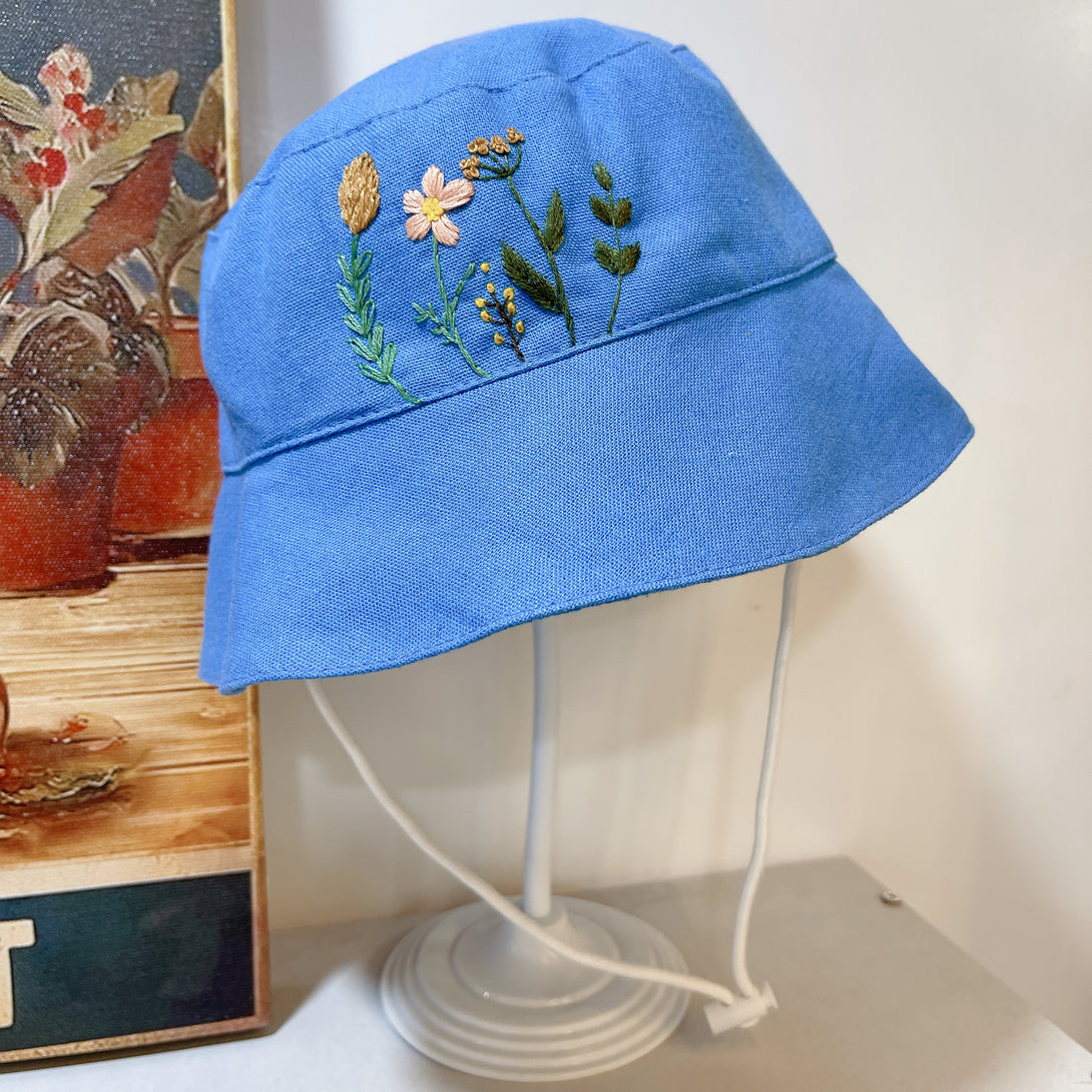 Stitchery Zone blue embroidered hat with floral design featuring Garden Linen Baby Hat style