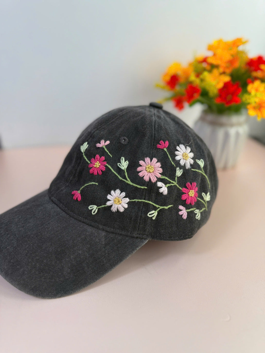 Colorful Daisy Hand Embroidered Hat in black with vibrant floral embroidery from Stitchery Zone