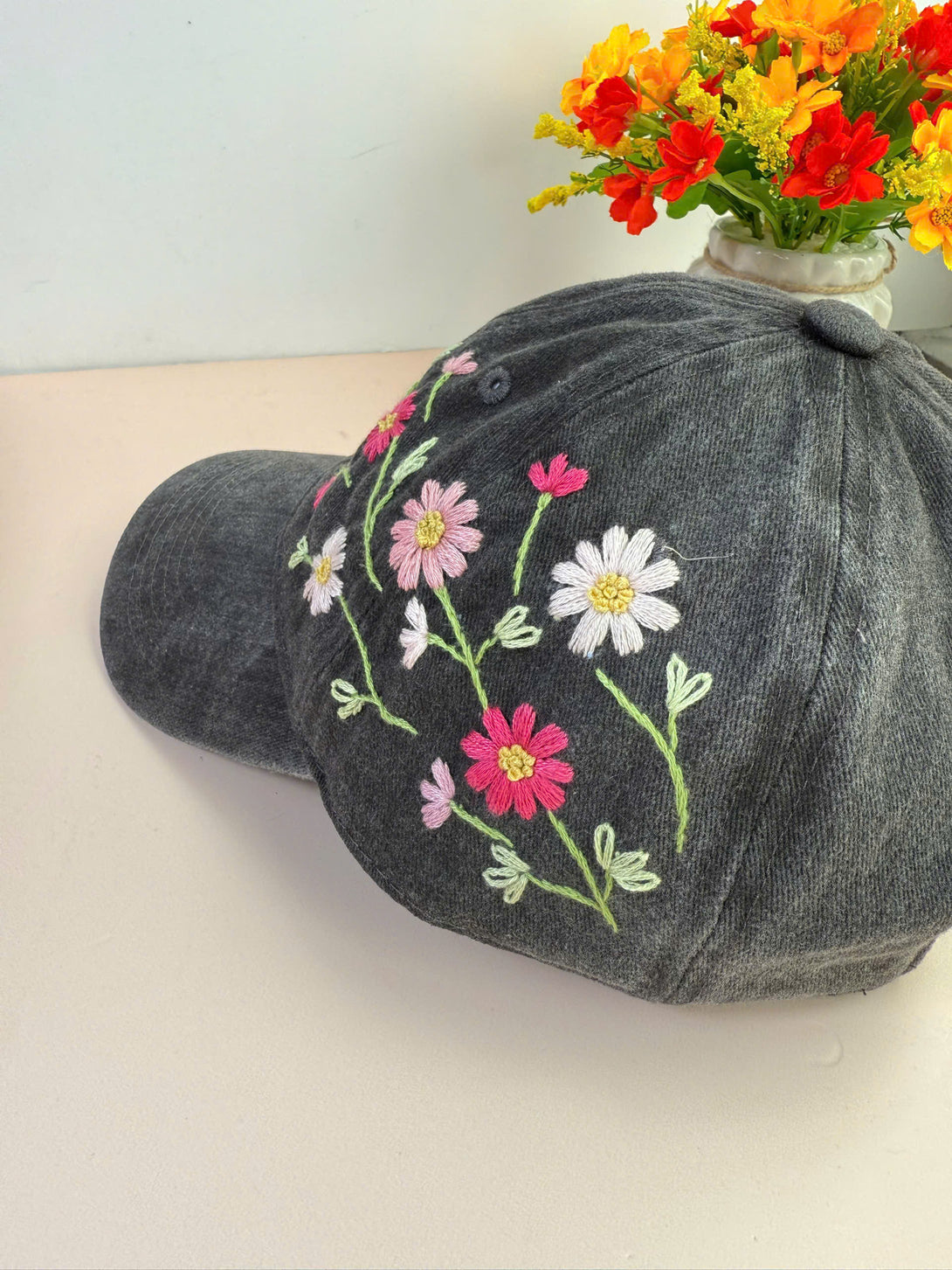 Colorful Daisy Hand Embroidered Hat by Stitchery Zone in dark gray with pink and white floral embroidery