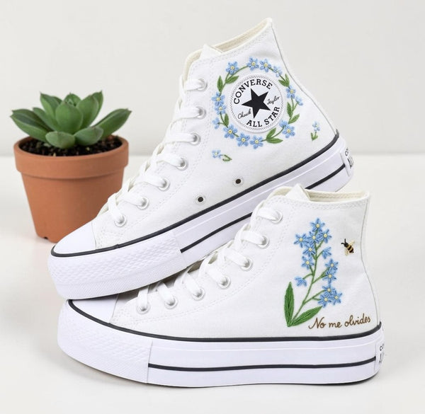 White Converse high-top shoes with blue flowers embroidery design, perfect for casual wear and stylish outfits