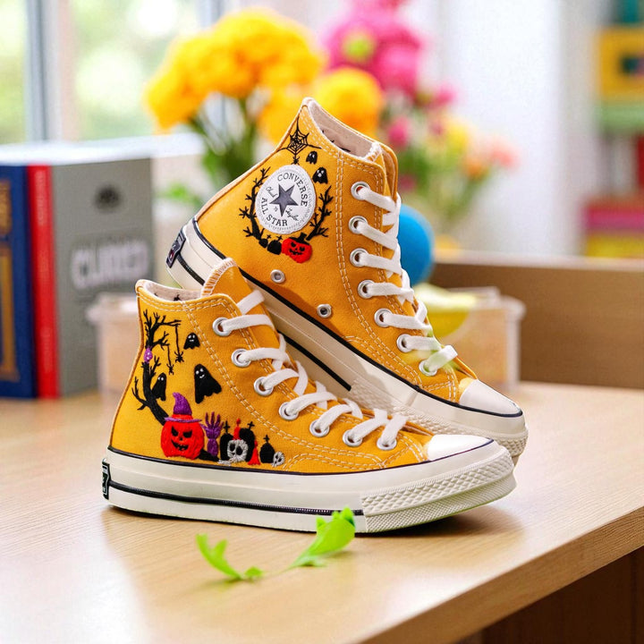 Yellow embroidered high top Halloween Converse with pumpkin skull bat designs and white rubber sole
