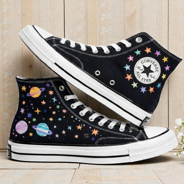Moon Converse high-top shoes with colorful planet and star embroidered designs on a black background