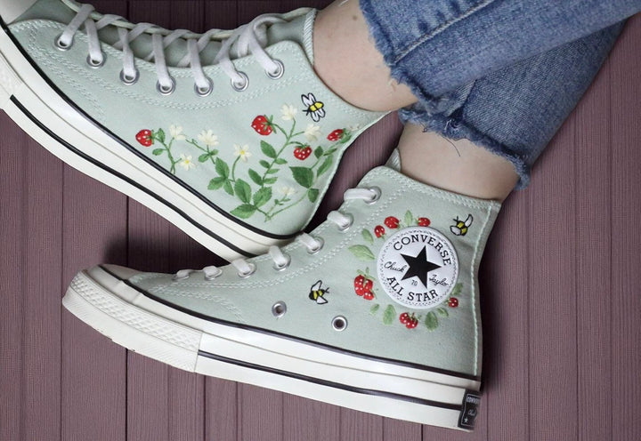 Stitchery Zone embroidered light green high top strawberry converse with red strawberries bees and leafy vines worn with frayed jeans