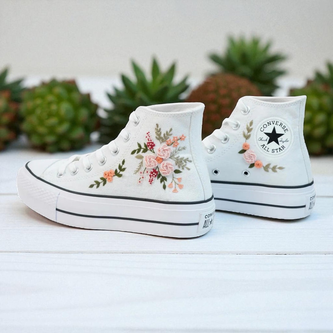 White Converse high top embroidered shoes with pink and green floral design on white canvas