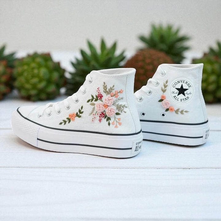 White Converse high top embroidered shoes with pink and green floral design on white canvas