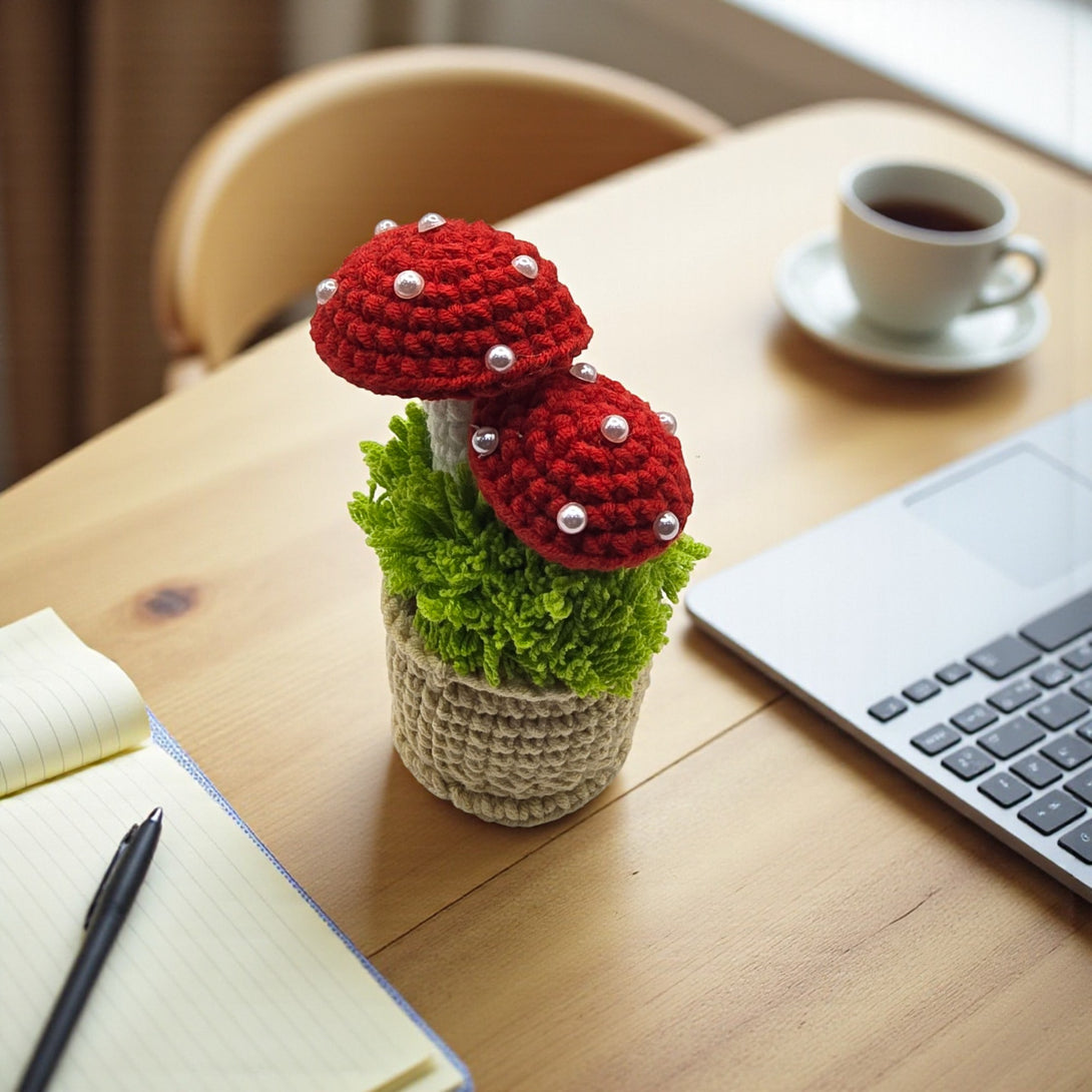 Crochet mushroom centerpieces with red tops and pearl accents in a decorative pot