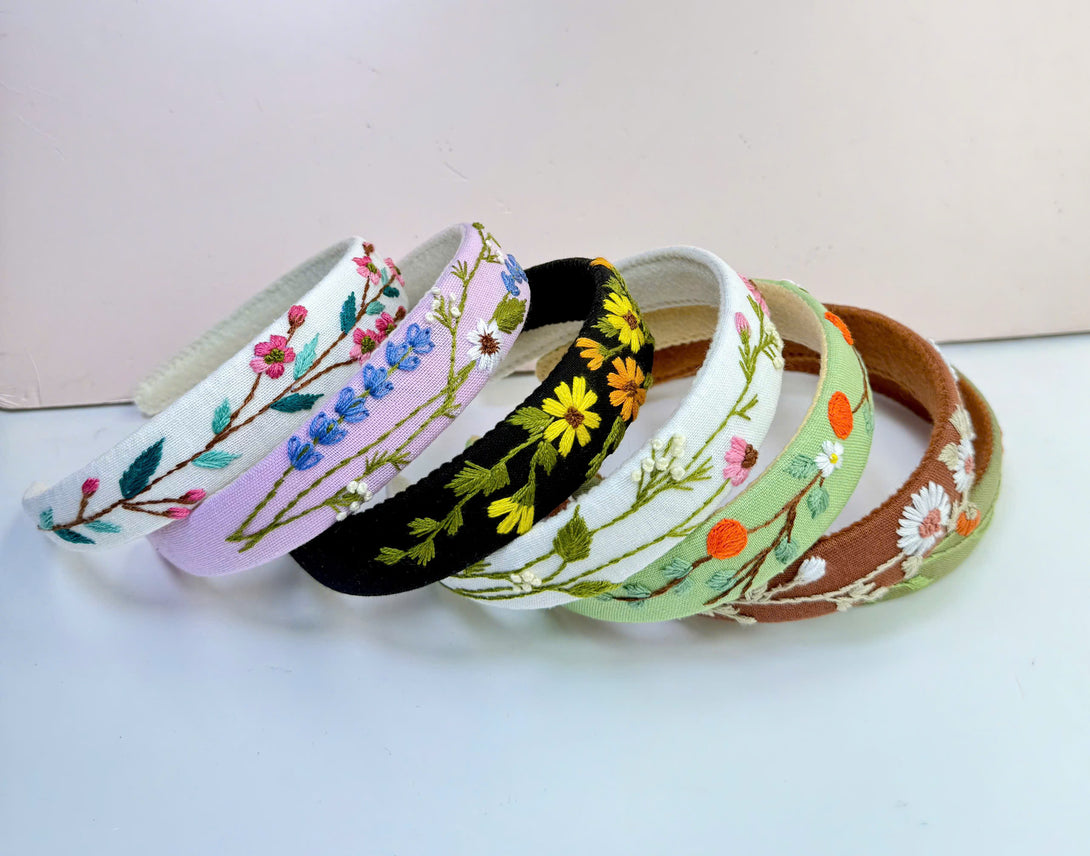 Stitchery Zone embroidered custom headbands with colorful floral designs on various fabric colors