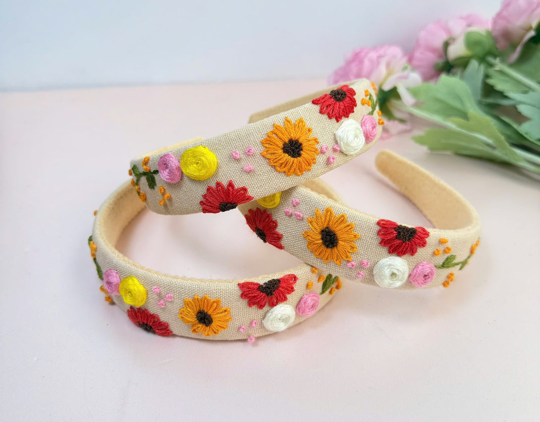 Stitchery Zone embroidered custom headbands with colorful floral designs on beige fabric