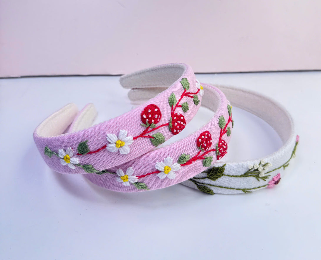 Stitchery Zone embroidered custom headbands with floral and strawberry designs in pink and white fabric
