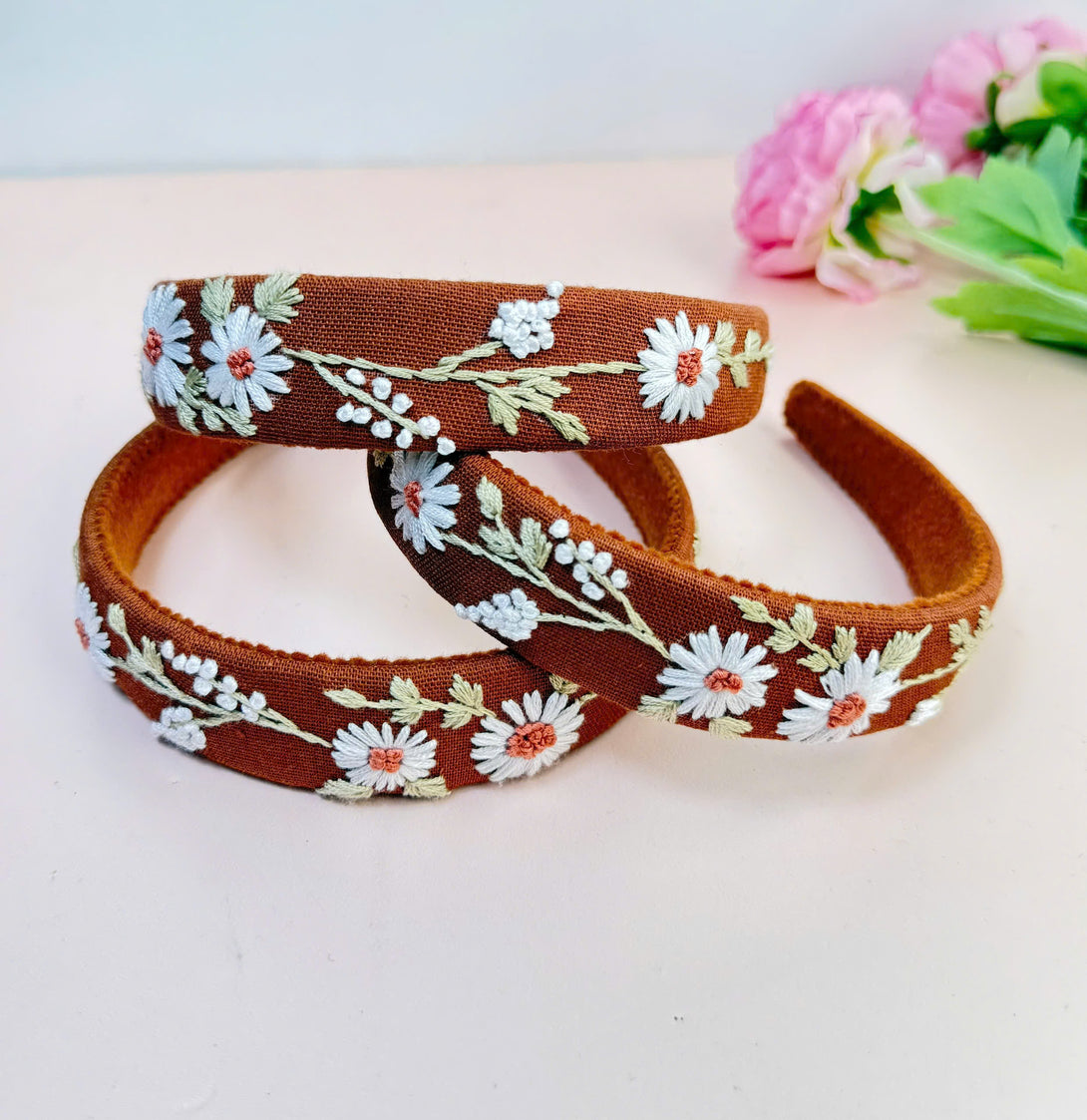 Stitchery Zone embroidered custom headbands with white floral design on brown fabric hair accessories