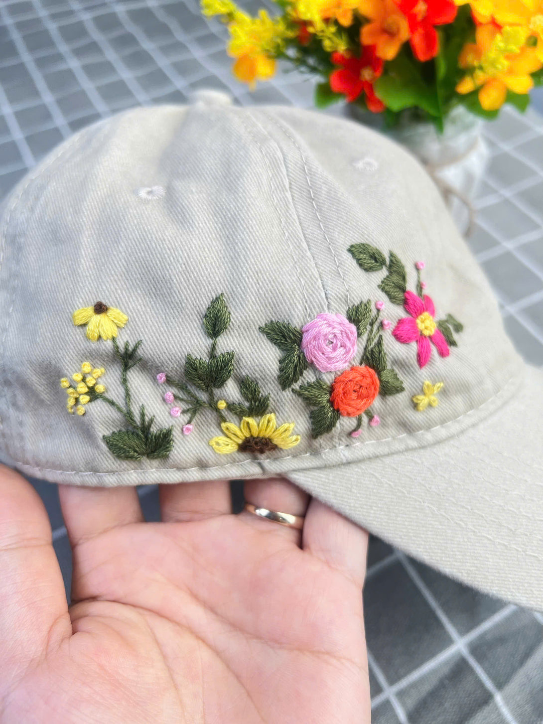 Stitchery Zone embroidered hat with colorful floral designs on beige fabric