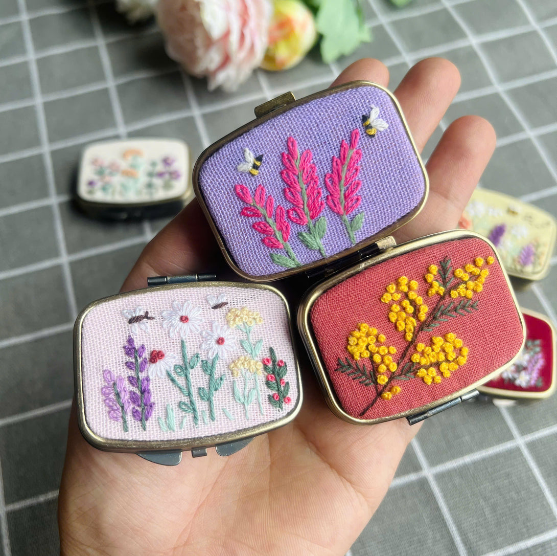 Embroidered Jewelry Box with floral and bee designs in various colors held in hand by Stitchery Zone