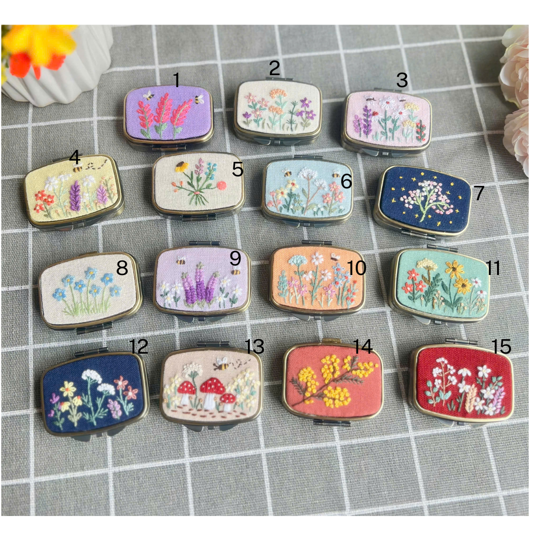 Stitchery Zone embroidered jewelry box mirror with colorful floral designs in various pastel and dark backgrounds