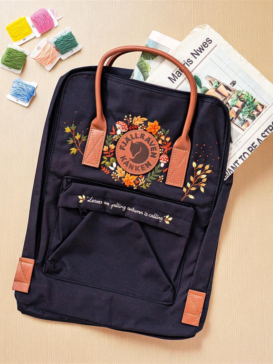 Classic Fjallraven Kanken Backpack black embroidered floral design with tan leather handles and front pocket