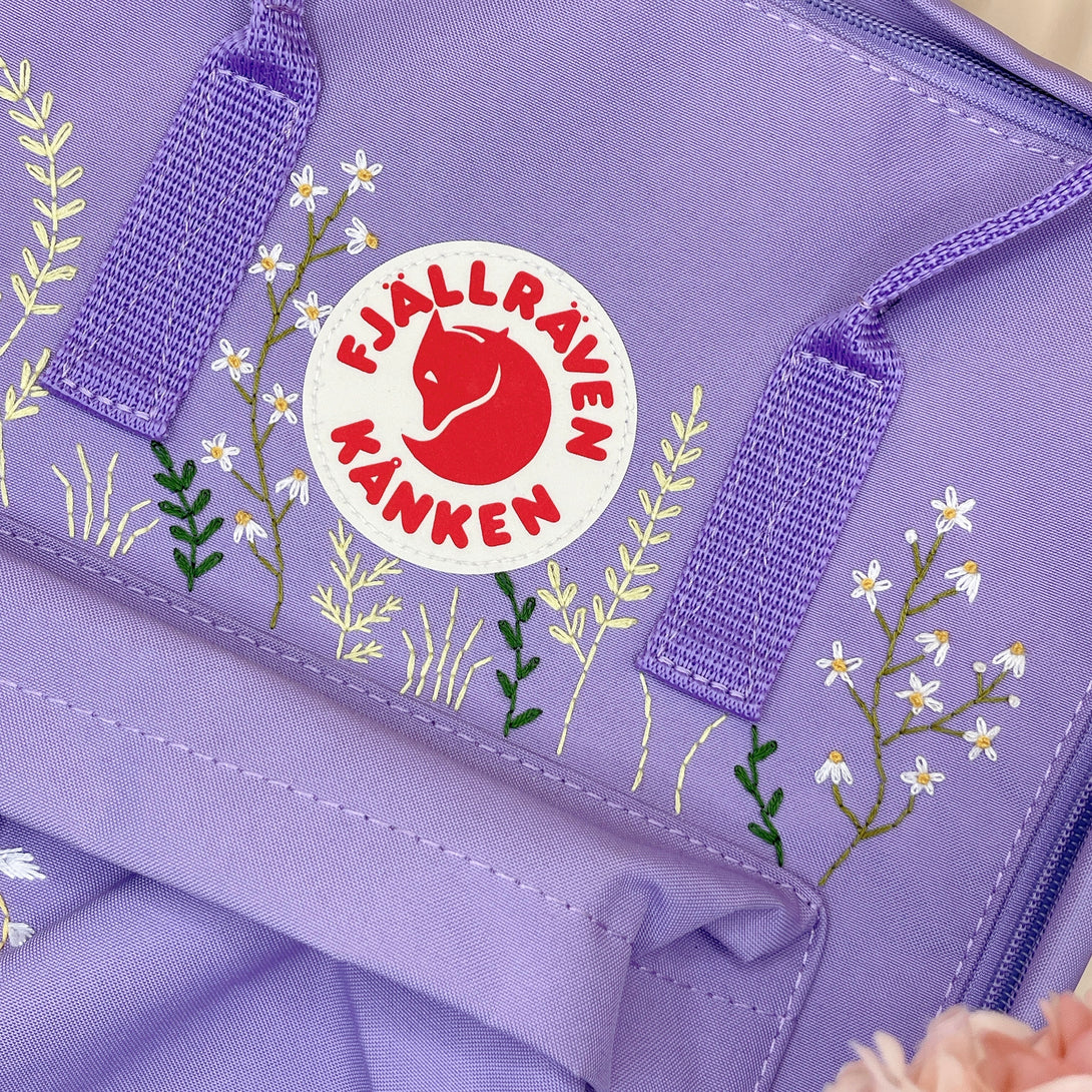 Lavender embroidered custom backpack with floral design and Fjallraven Kanken logo patch