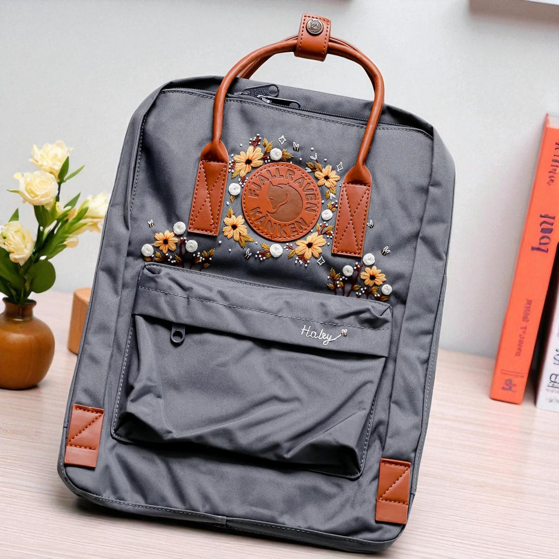 Stitchery Zone gray Fjallraven Kanken Backpack with brown leather handles and embroidered floral patch
