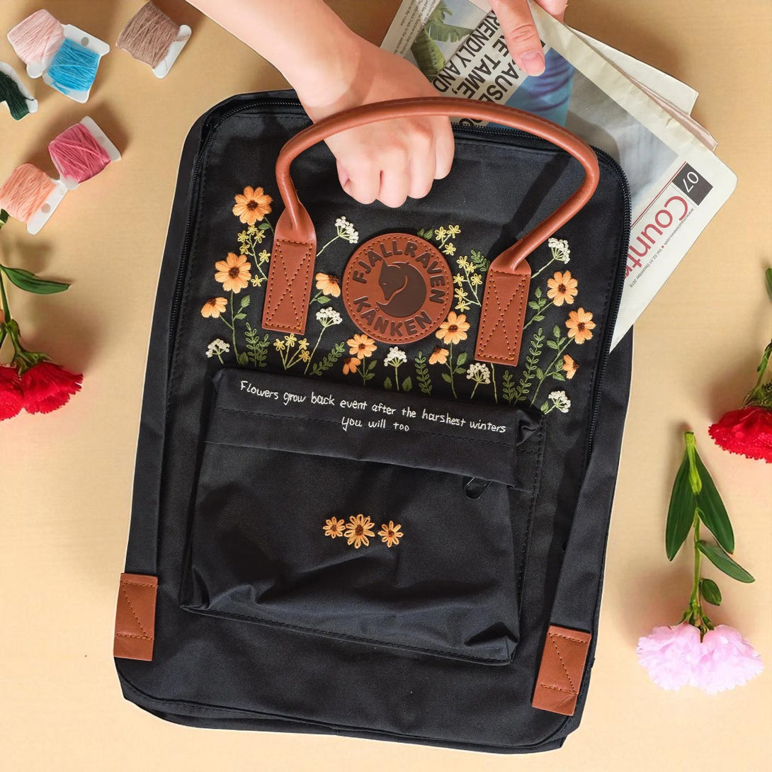 Stitchery Zone black floral embroidered backpack with brown handles and front pocket Fjallraven Kanken Backpacks