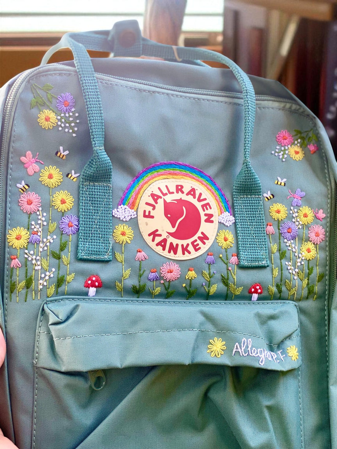 Stitchery Zone Fjallraven Kanken Mini Backpack green with embroidered wildflowers rainbow patch and mushrooms