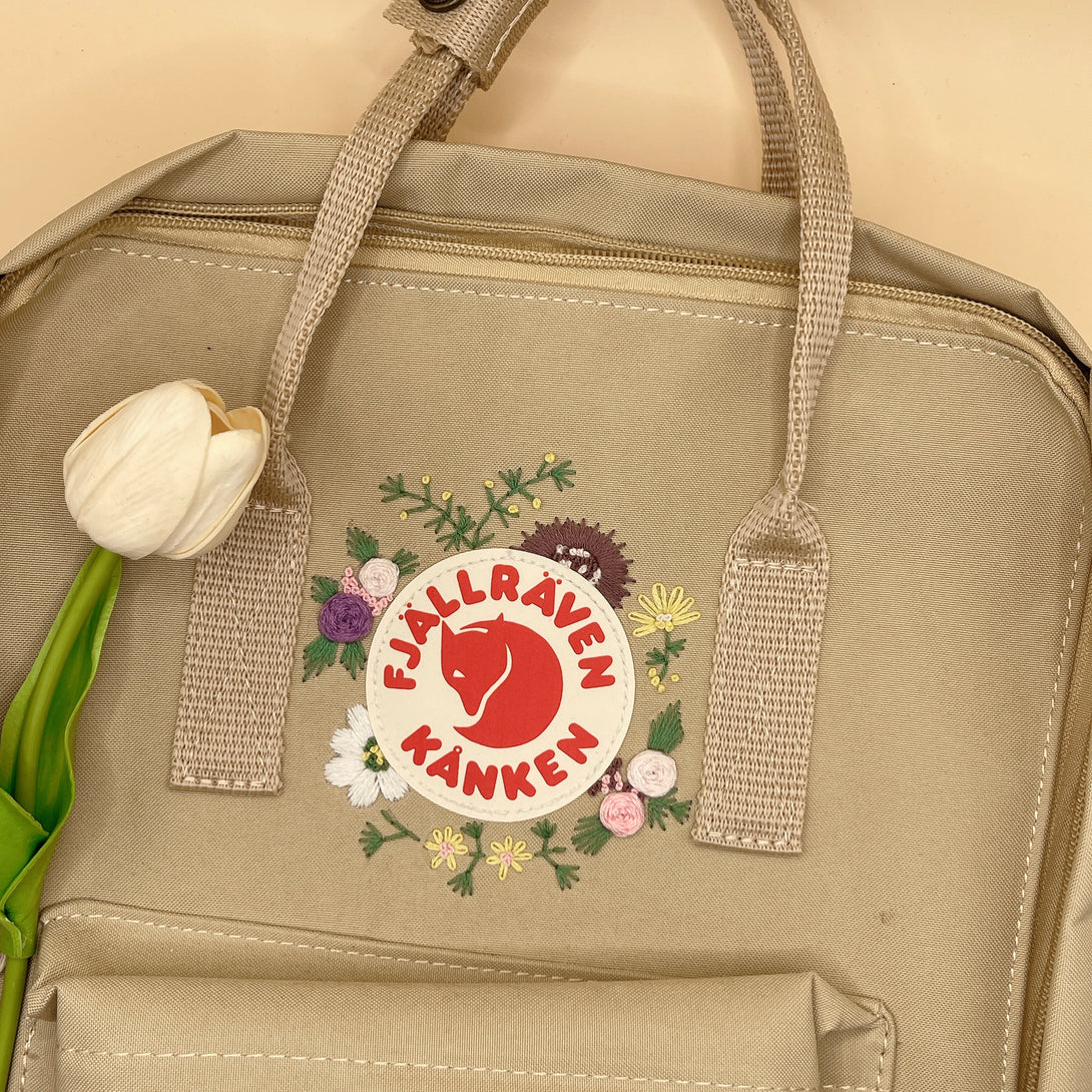 Beige floral embroidery school bag by Stitchery Zone with colorful flower designs and sturdy handles