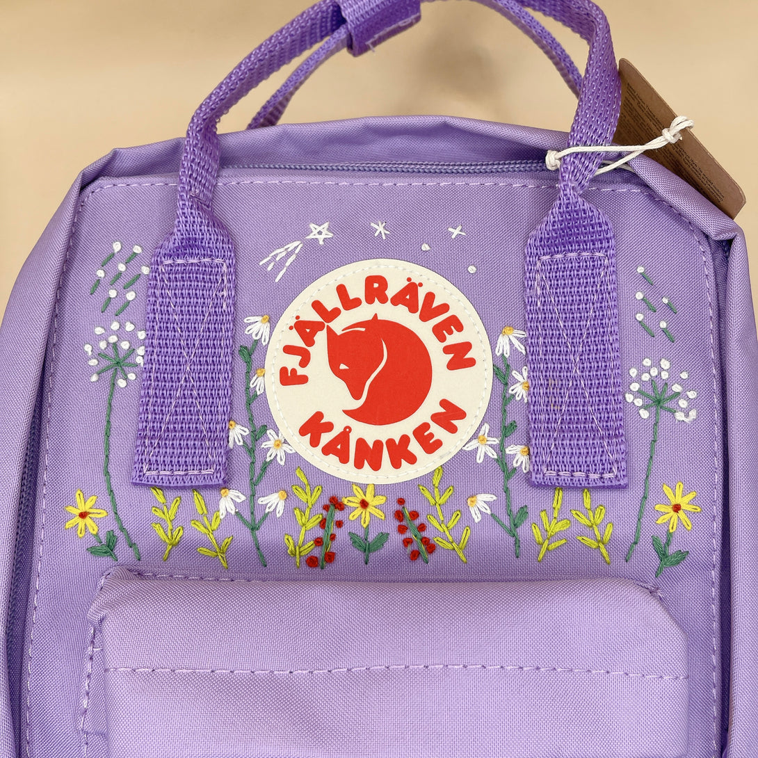 Purple Fjallraven Kanken backpack with floral hand embroidery and hand embroidered backpack design