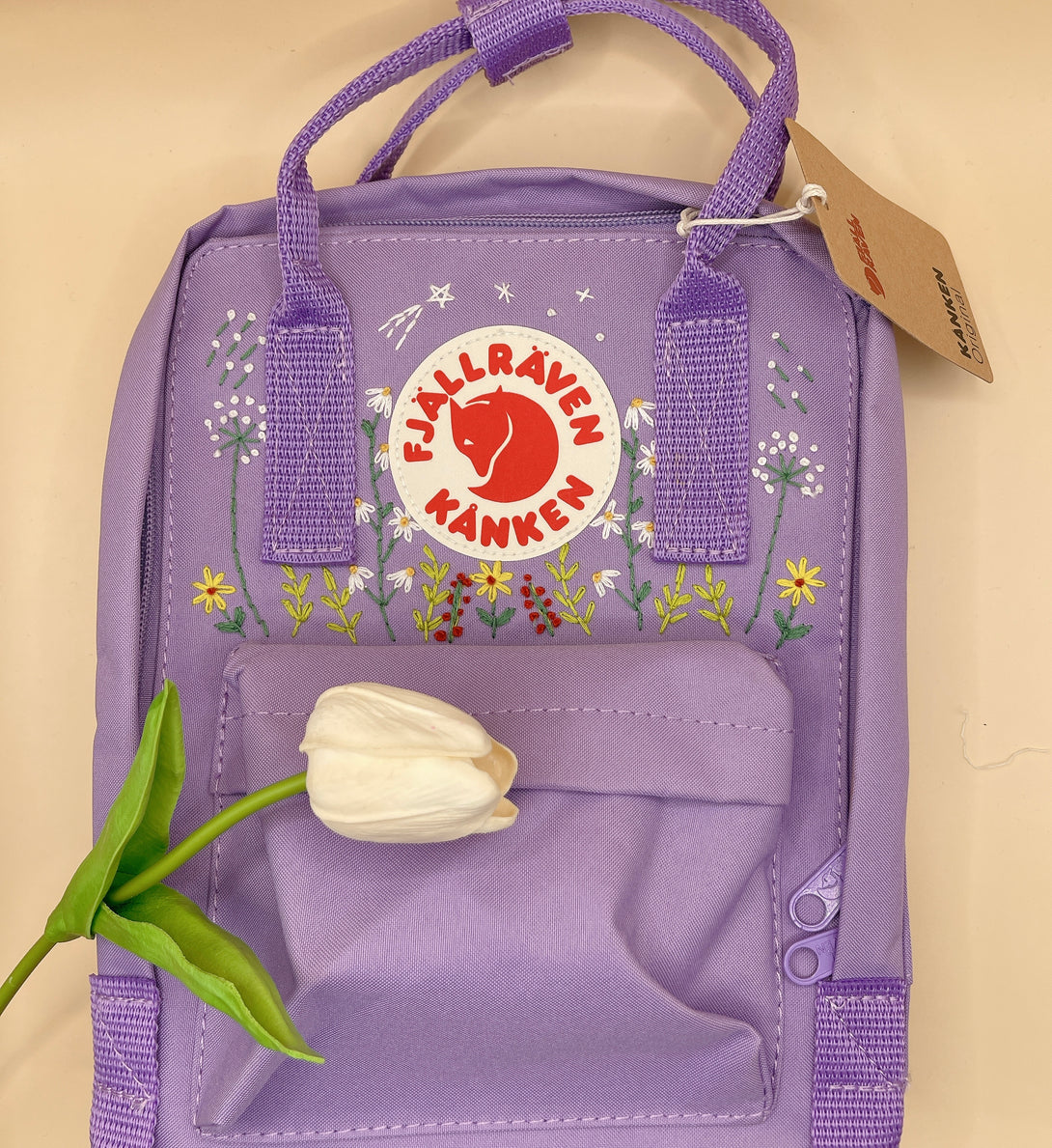 Lavender hand embroidered backpack from Stitchery Zone with floral details and front pocket