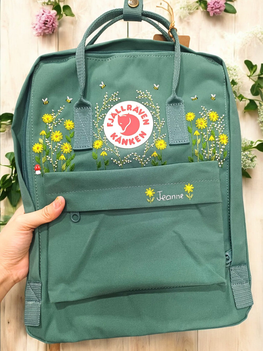 Fjallraven Kanken Laptop 15 Backpack in green with floral embroidery and front pocket