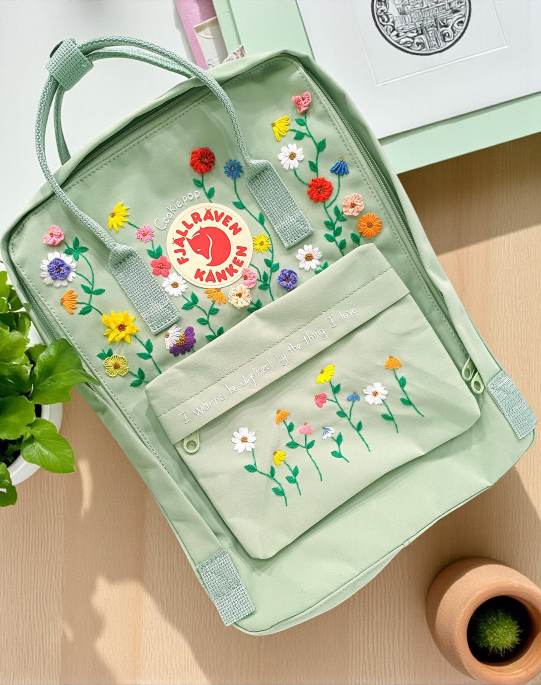 Fjallraven Kanken laptop backpack in green with colorful floral embroidery design