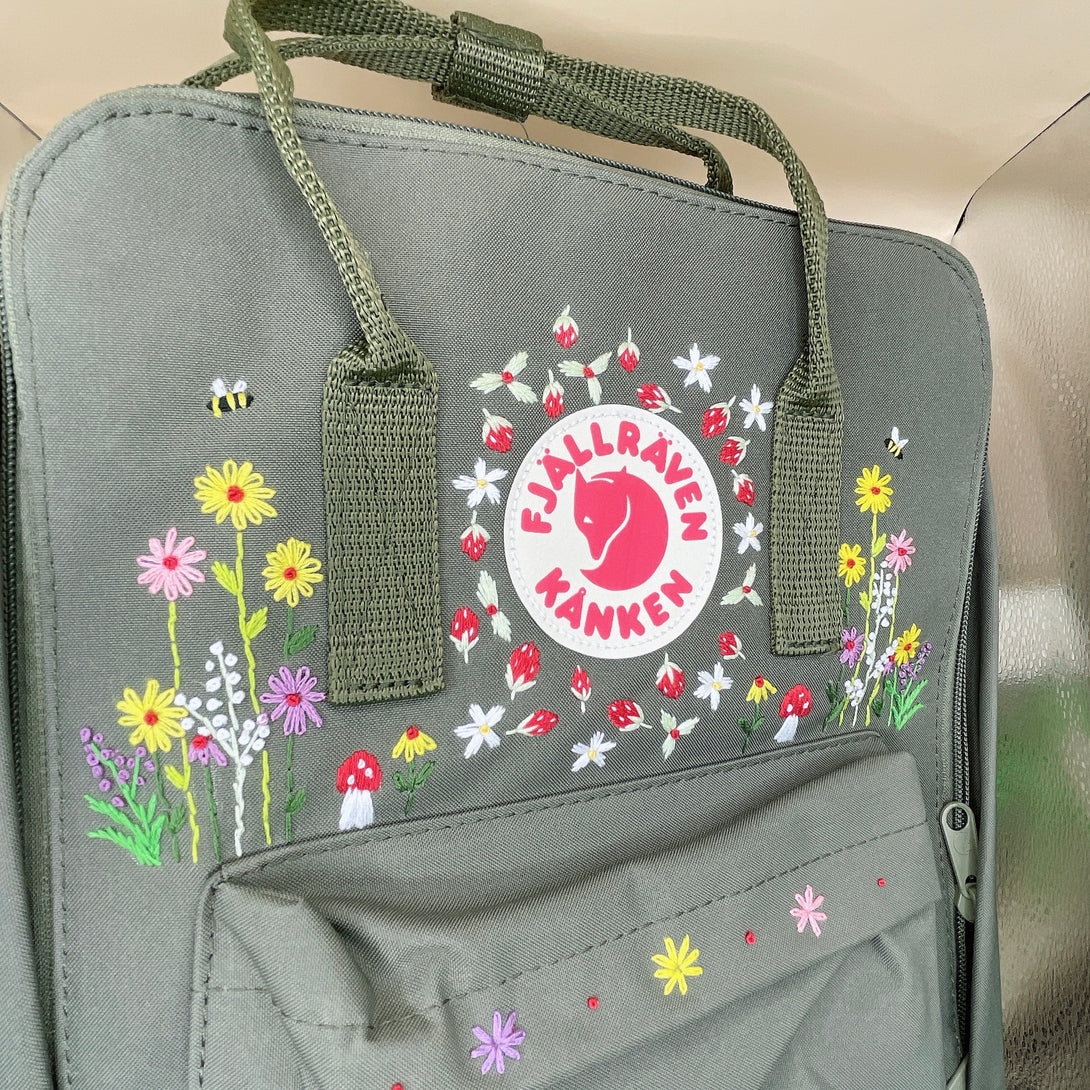 Unique floral backpack for school by Stitchery Zone featuring colorful embroidered flowers and sturdy green straps
