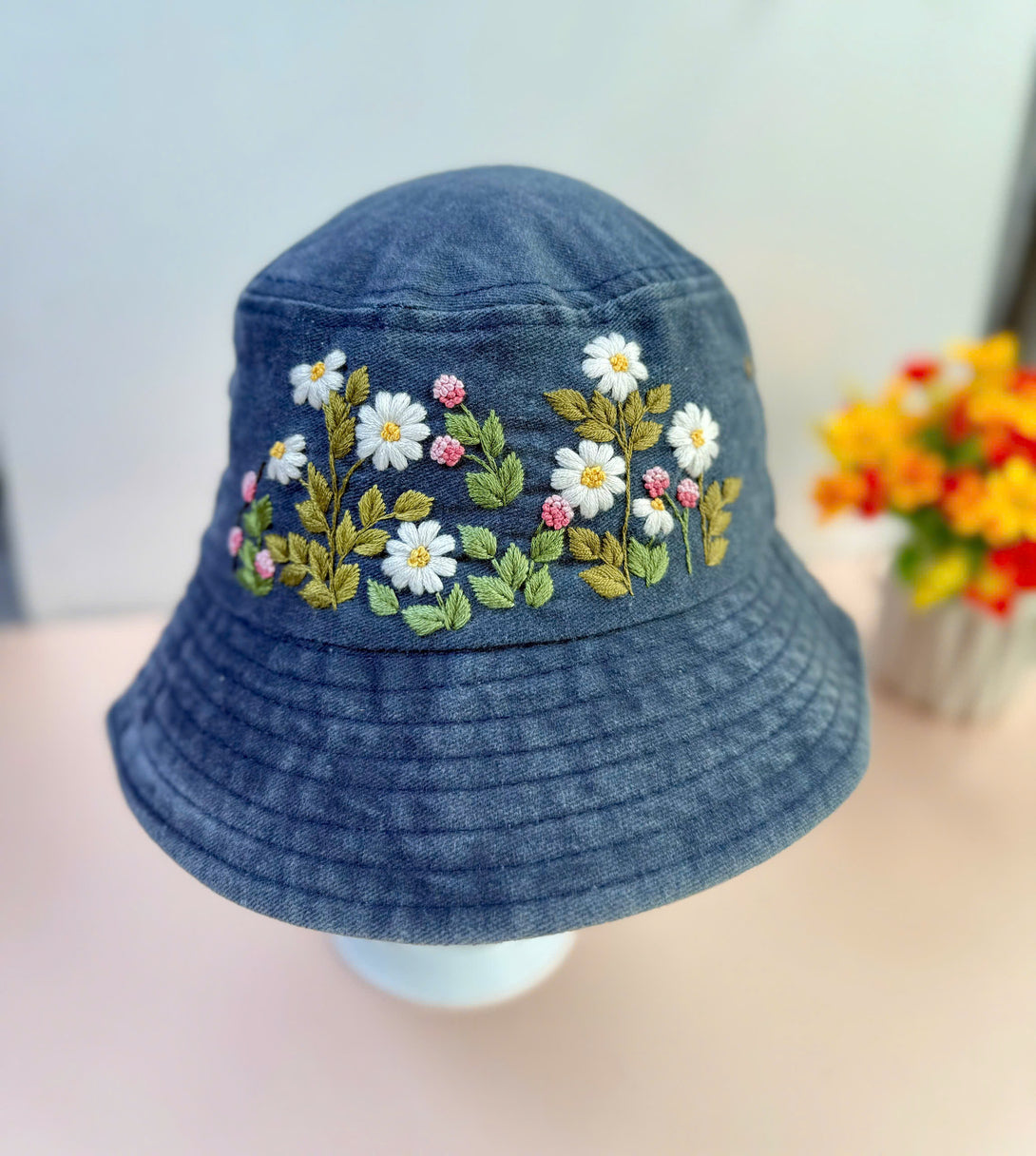 Flower Garden Hand Embroidered Bucket Hat by Stitchery Zone with white and pink floral design on denim fabric