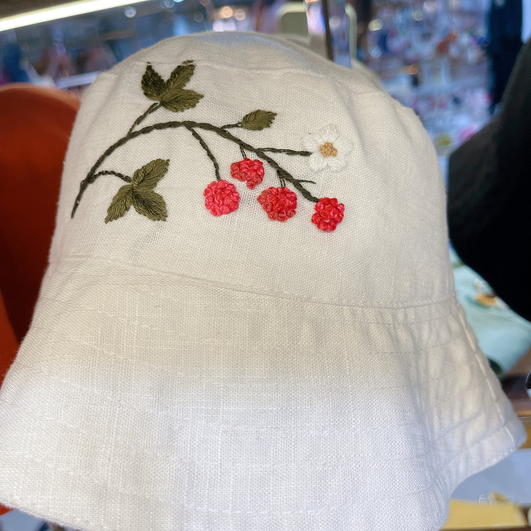 Hand Embroidered Berry Linen Baby Hat by Stitchery Zone featuring red berries and green leaves embroidery