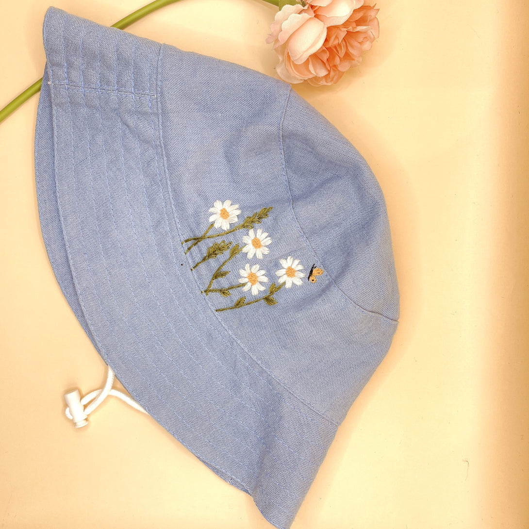 Hand Embroidered Daisy and Bee Linen Baby Hat in light blue with floral embroidery on brim