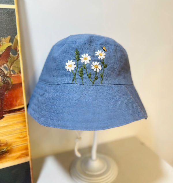Hand Embroidered Daisy and Bee Linen Baby Hat in blue with floral and bee design by Stitchery Zone