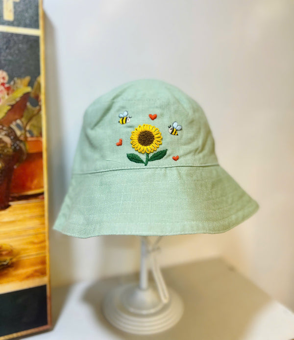 Hand Embroidered Sunflower and Bee Linen Baby Hat by Stitchery Zone in light green with yellow sunflower and bees