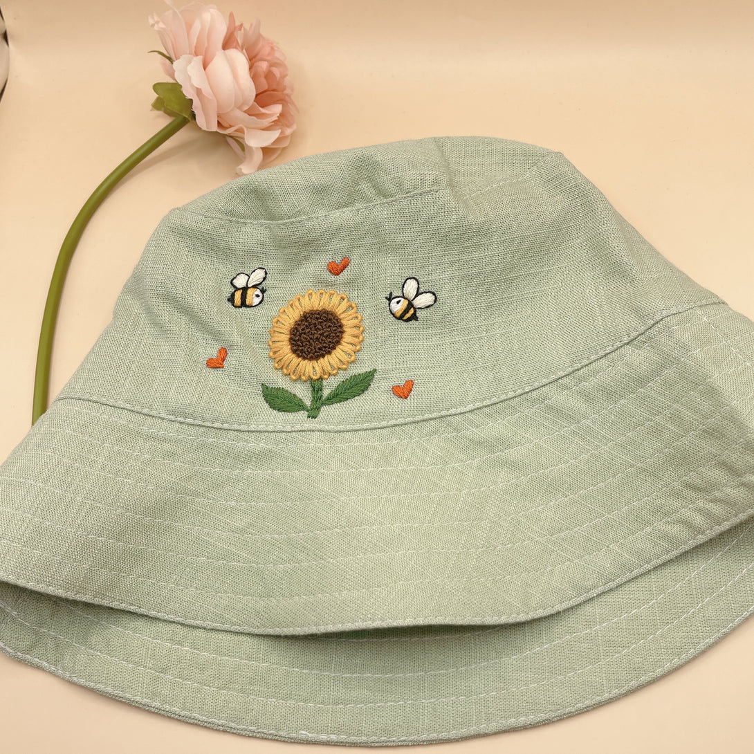 Hand Embroidered Sunflower and Bee Linen Baby Hat in light green with detailed stitching by Stitchery Zone