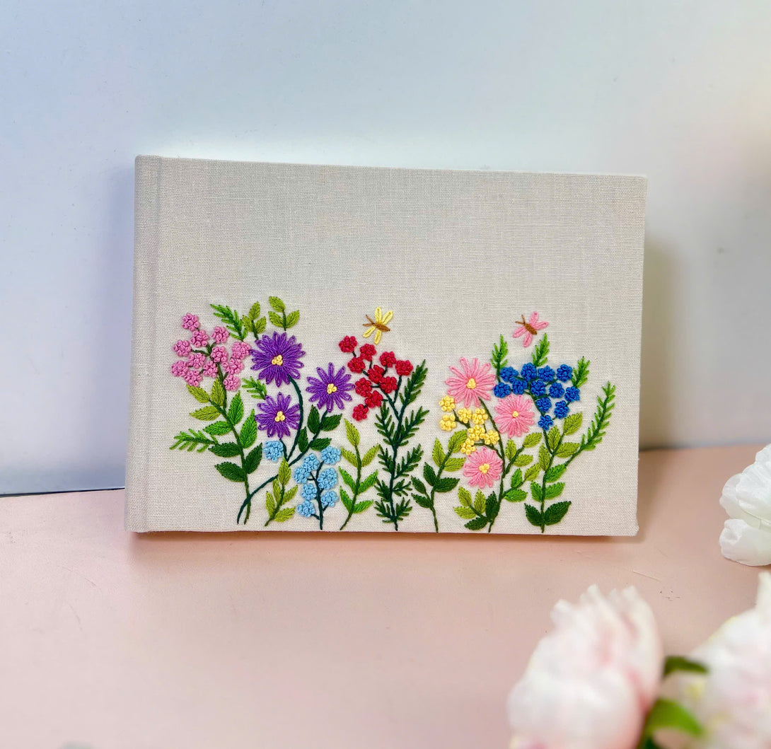 Handmade Wedding Guest Book by Stitchery Zone with embroidered colorful flowers on fabric cover