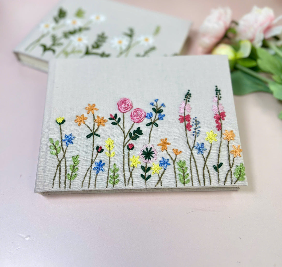 Handmade Wedding Guest Book by Stitchery Zone with colorful embroidered flowers on linen cover