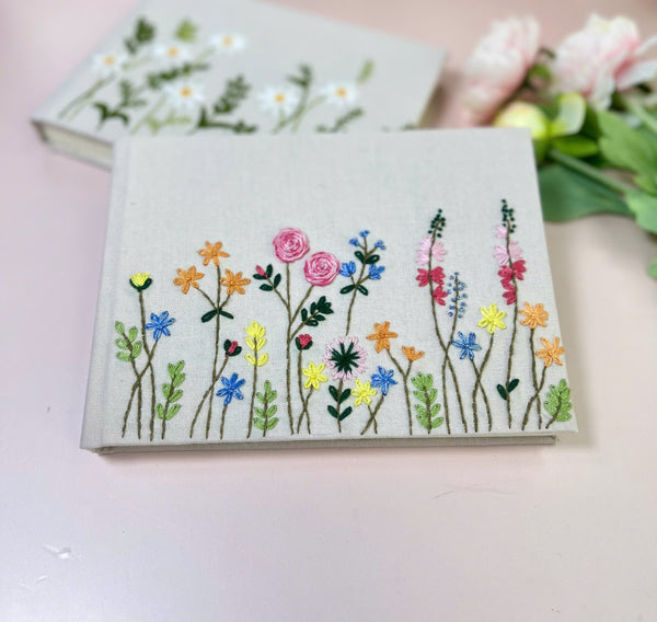 Handmade Wedding Guest Book by Stitchery Zone with colorful embroidered flowers on linen cover