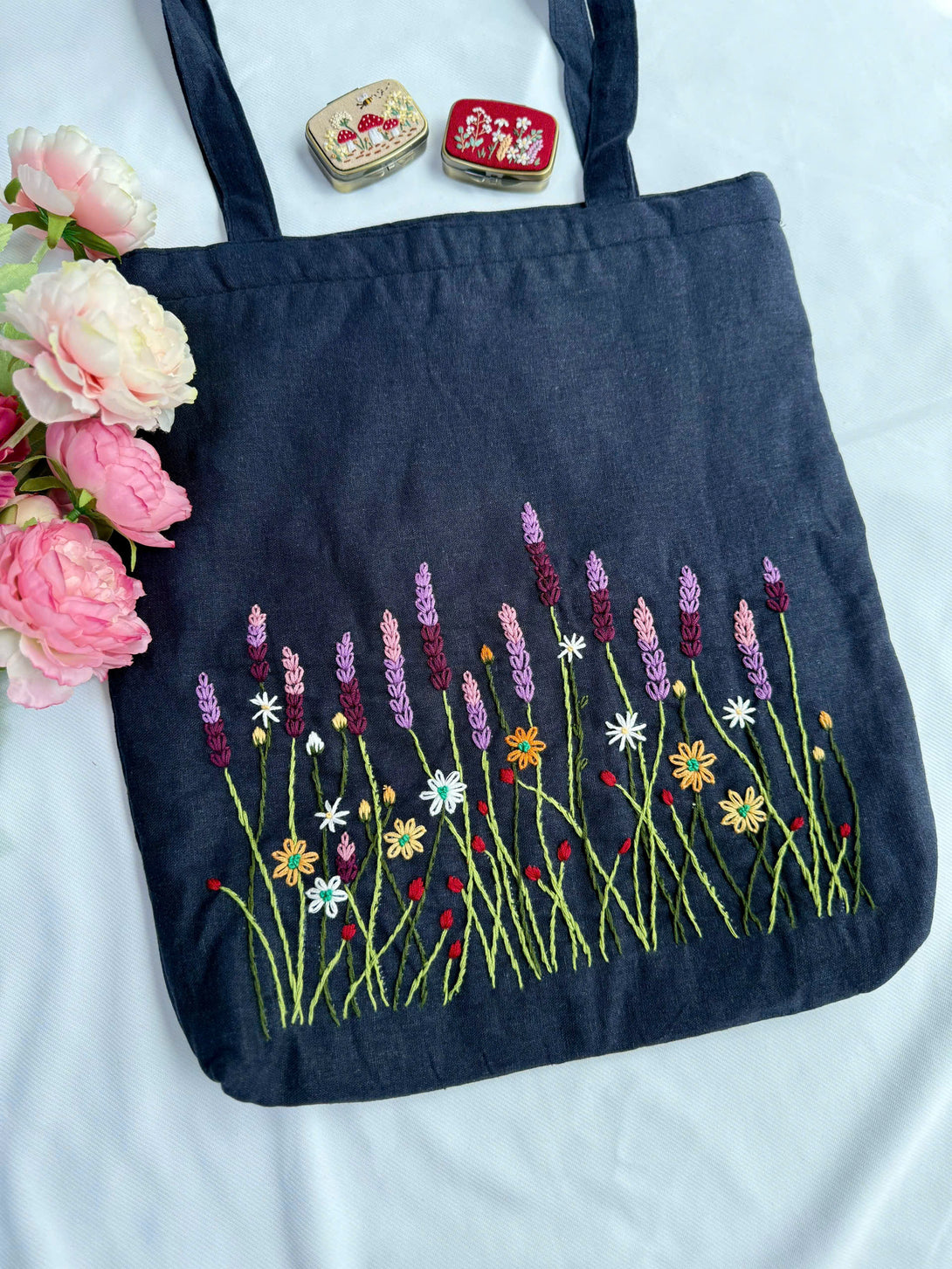 Lavender Garden Hand Embroidered Tote Bag by Stitchery Zone with colorful floral design on dark fabric