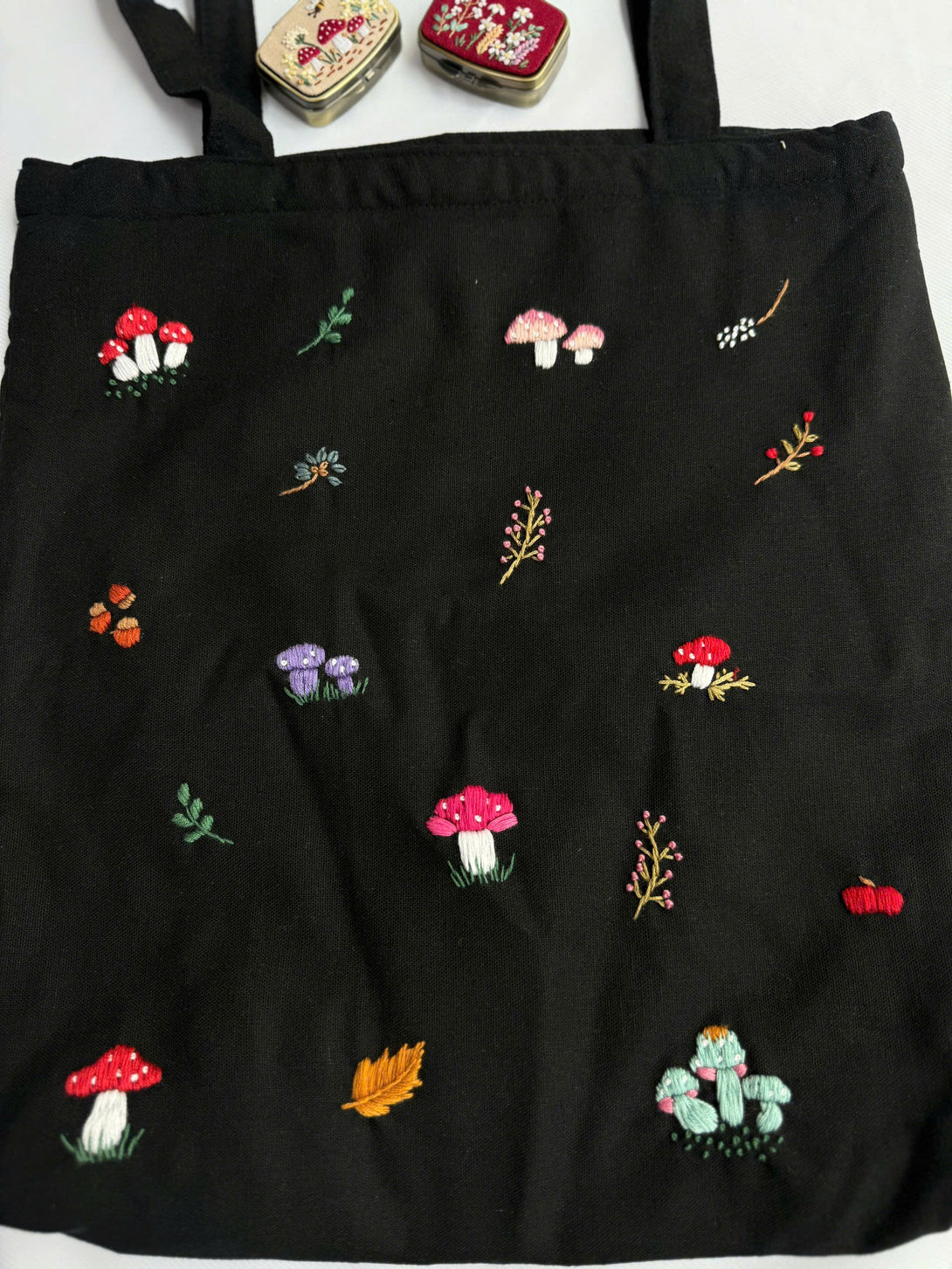 Black Mushroom Embroidered Tote Bag with colorful mushroom and plant designs by Stitchery Zone