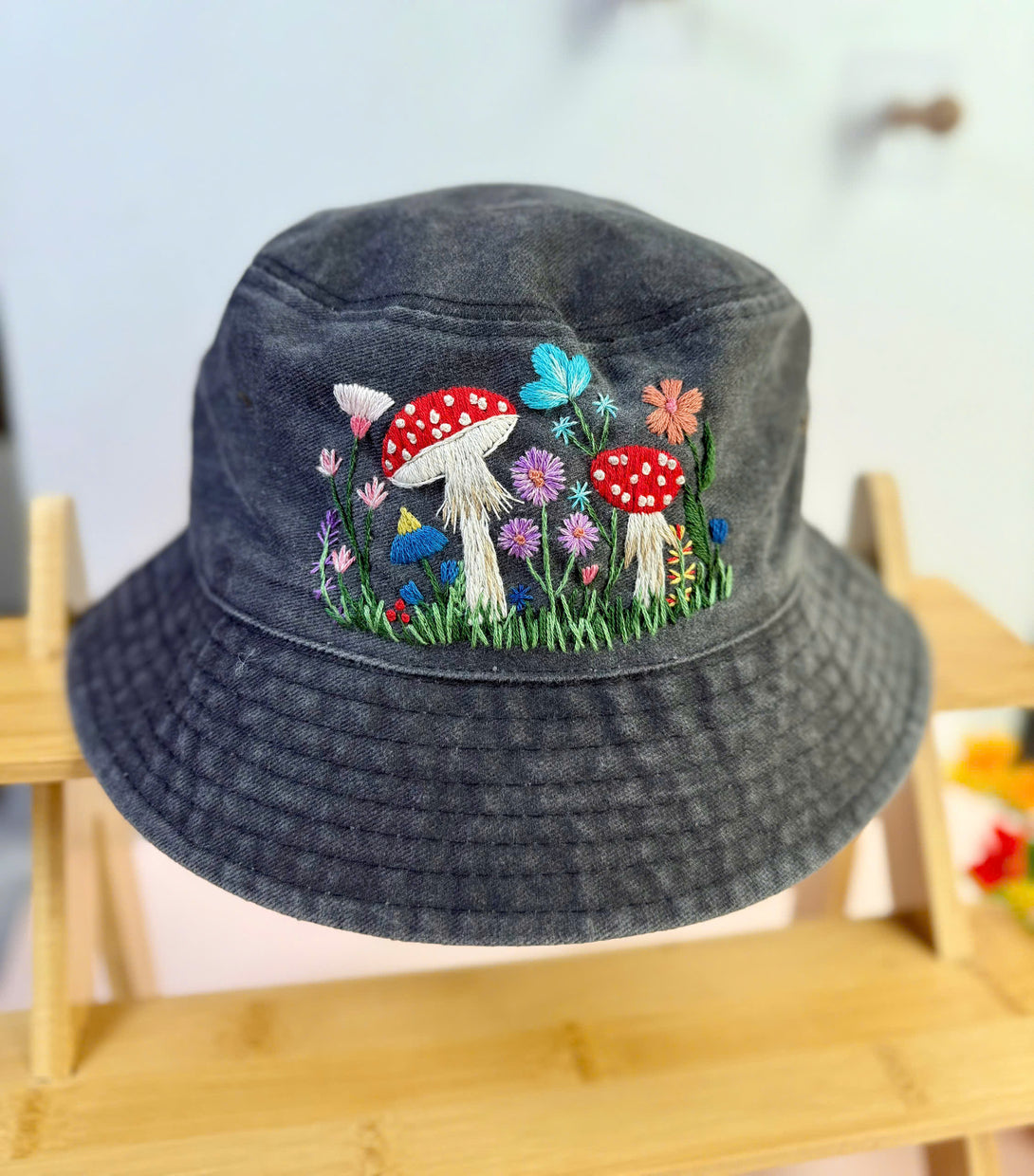 Mushroom Hand Embroidered Bucket Hat by Stitchery Zone with colorful floral and butterfly design on charcoal fabric