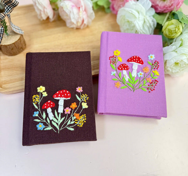 Mushroom Hand Embroidered Custom notebooks by Stitchery Zone with colorful floral designs on purple and brown covers