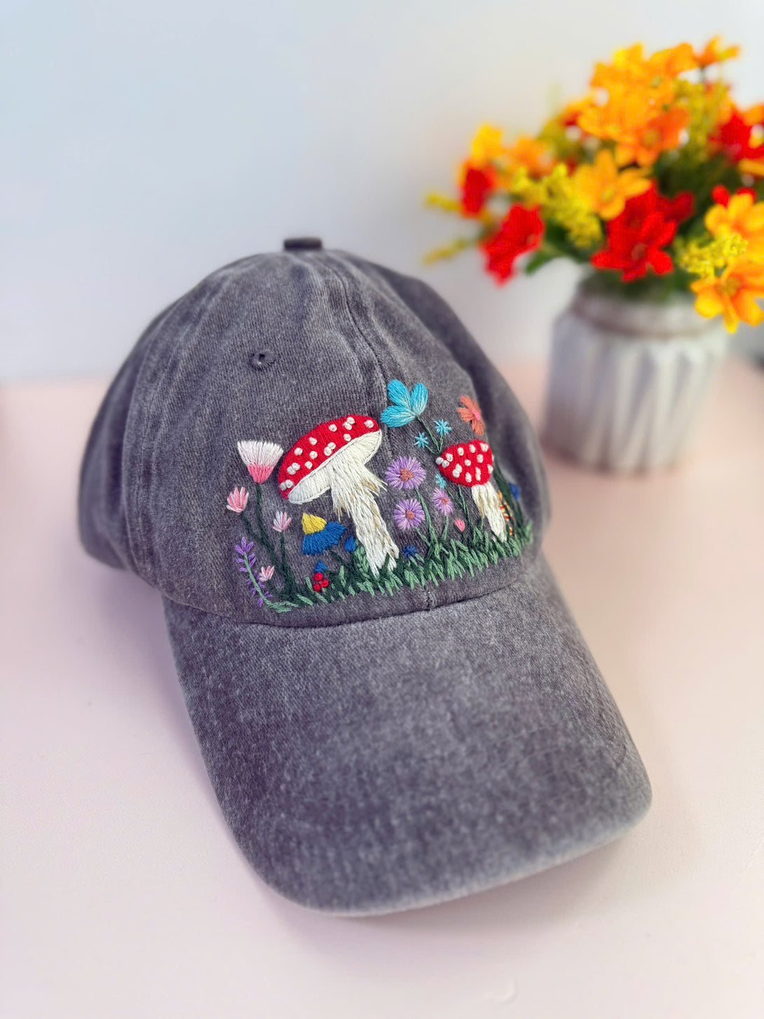 Stitchery Zone Mushroom Hand Embroidered Hat with colorful mushroom and floral design on gray cap