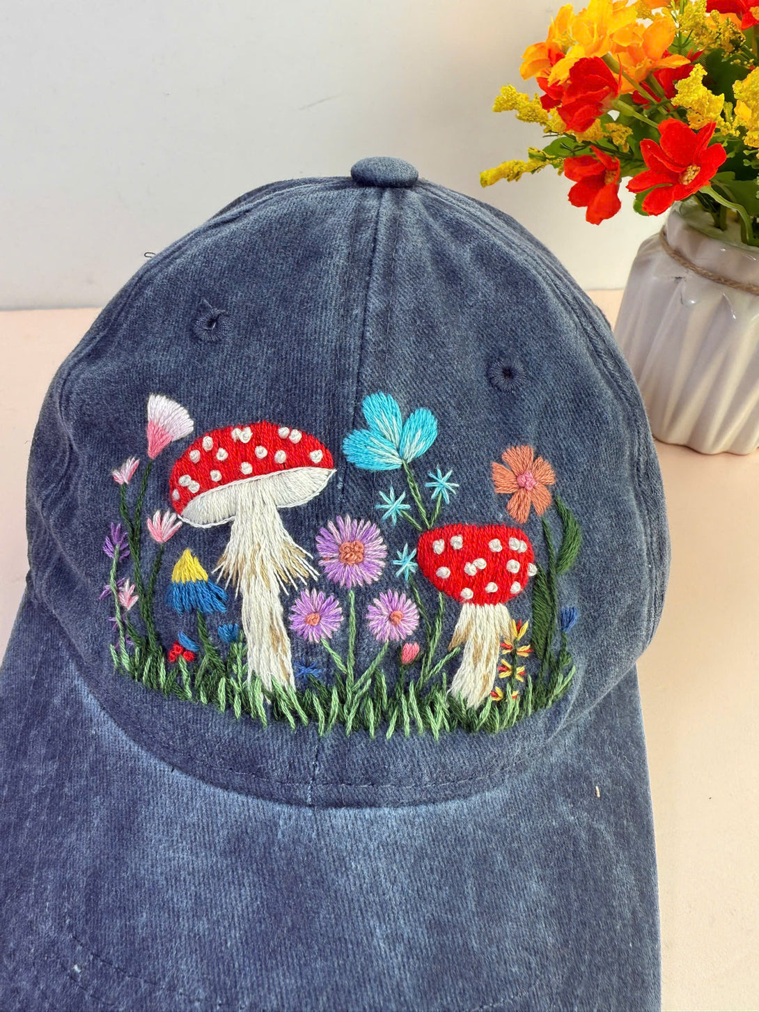 Mushroom Hand Embroidered Hat by Stitchery Zone with colorful floral and mushroom embroidery on blue fabric
