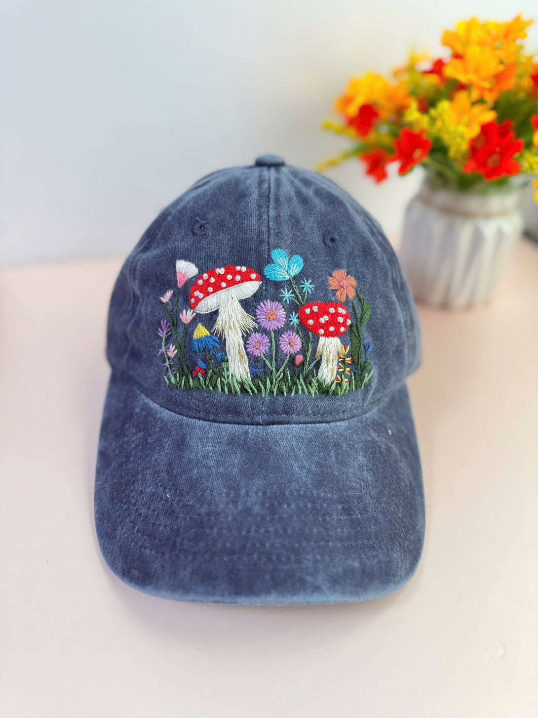 Stitchery Zone Mushroom Hand Embroidered Hat in faded blue with colorful mushroom and flower embroidery