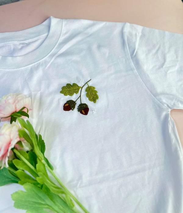 White nature inspired embroidered shirt by Stitchery Zone with green leaves and acorn design