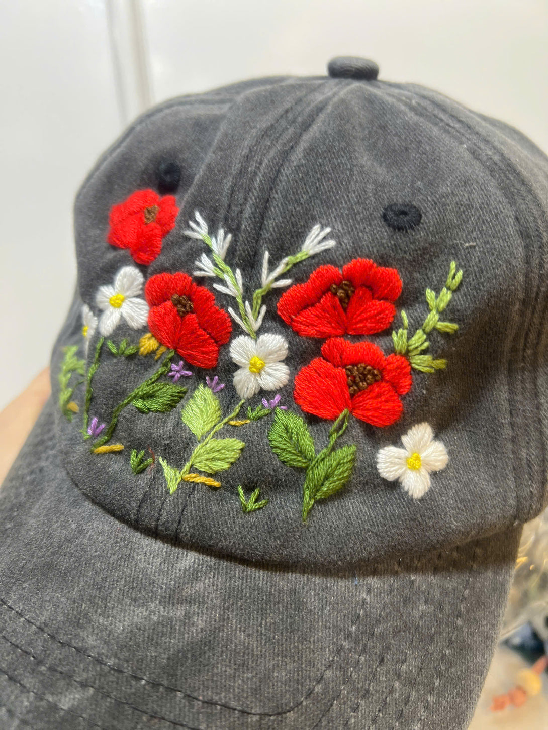 Peonies Hand Embroidered Hat with red and white floral design on a dark gray cap by Stitchery Zone