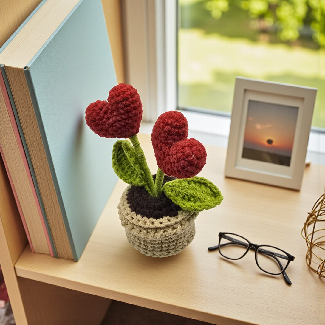 Red heart crochet pot featuring two heart-shaped flowers with green leaves