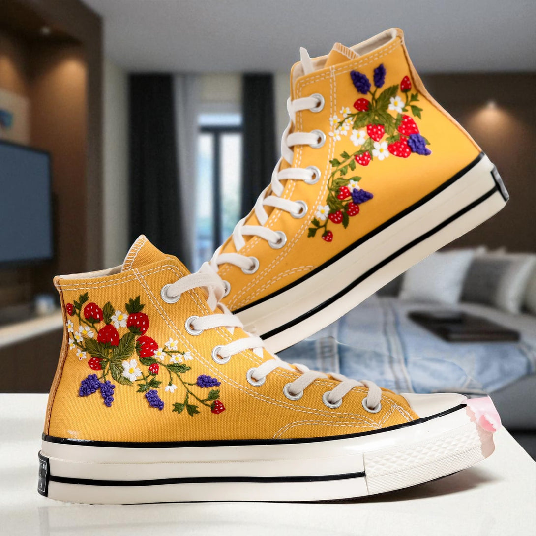 Strawberry Converse high-top shoes with vibrant floral embroidery on a yellow background