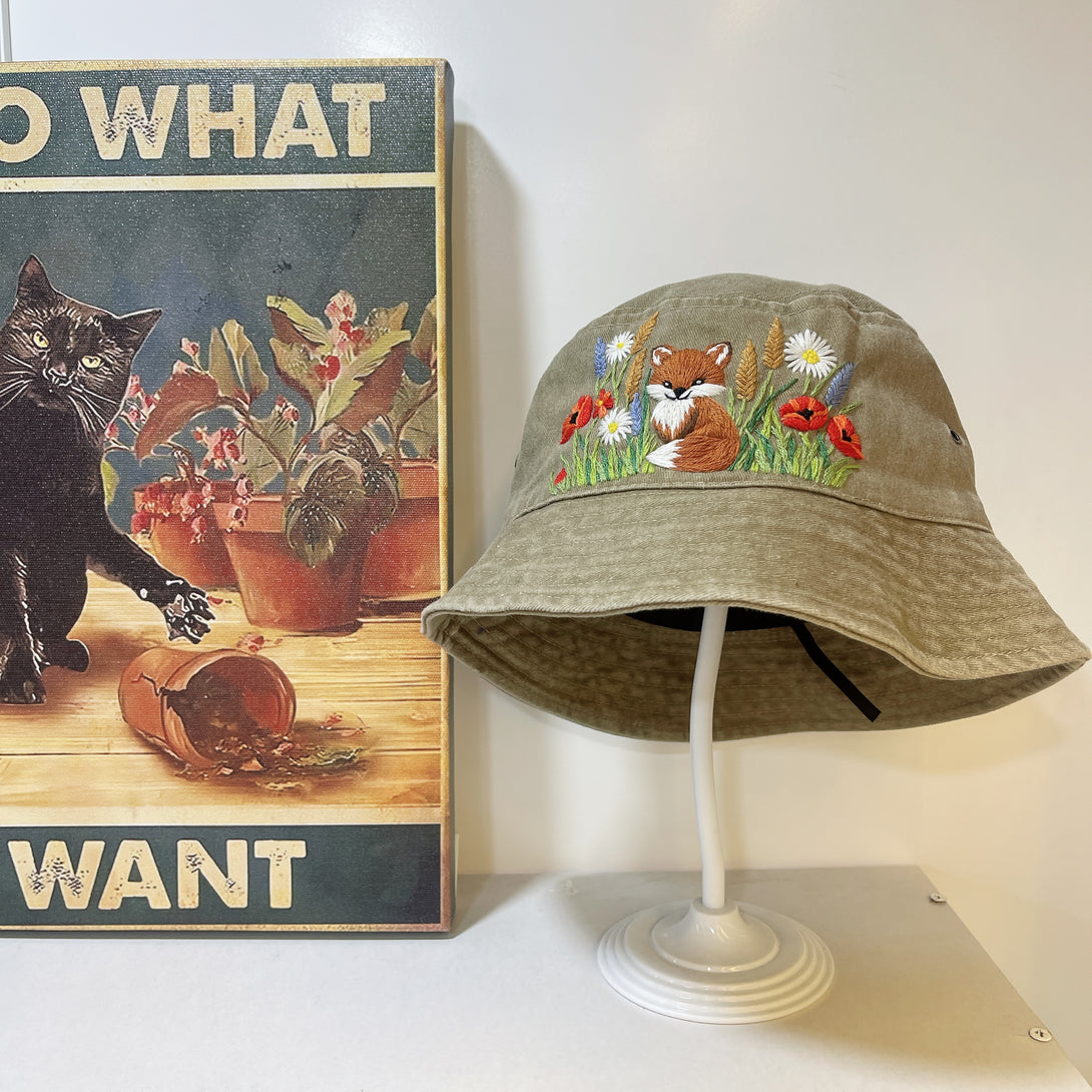 Summer Hat with Fox Embroidery by Stitchery Zone featuring a tan bucket hat with colorful fox and flower stitching